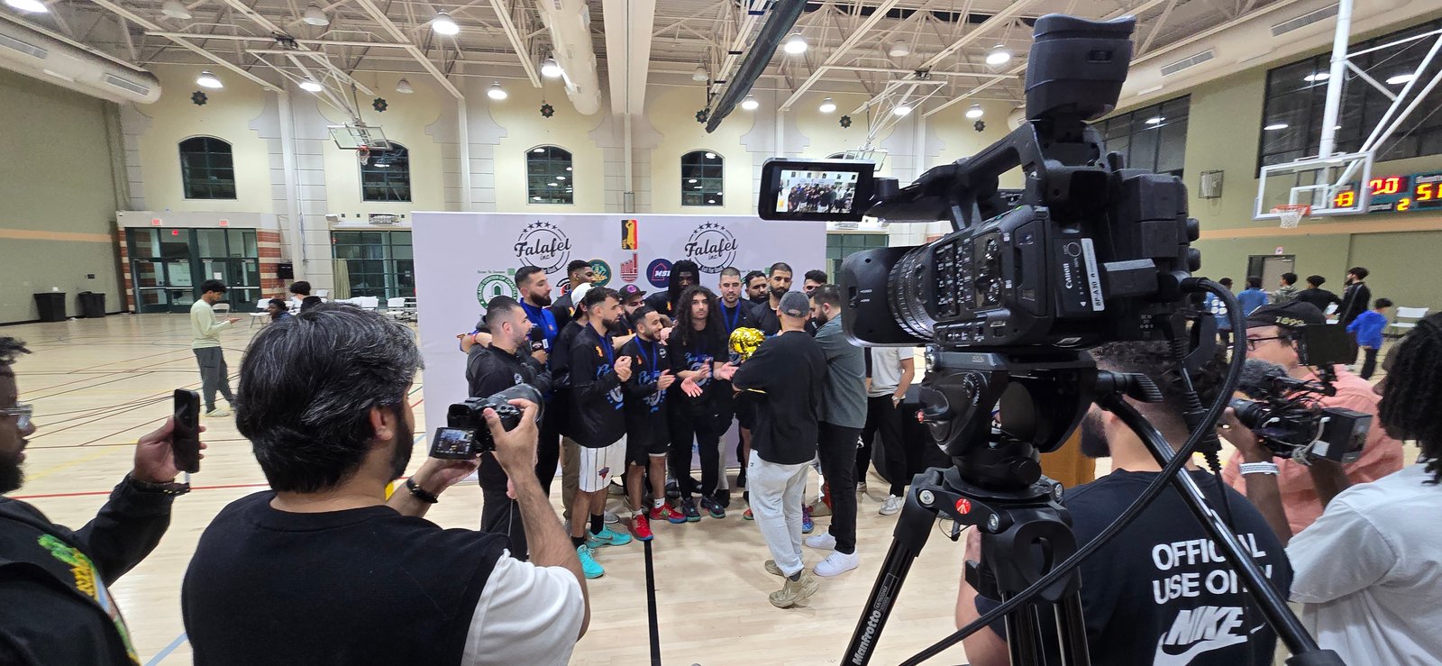 Broadcast camera capturing a championship team photo at center court